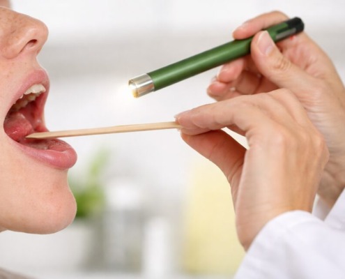 Halsuntersuchung mit Spatel und Licht