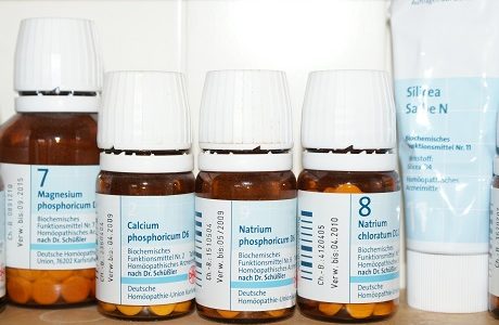 Vier Flaschen im Schüßler Salzen in Tabelttenform und eine Schüßler Salz Creme stehen in einem Regal